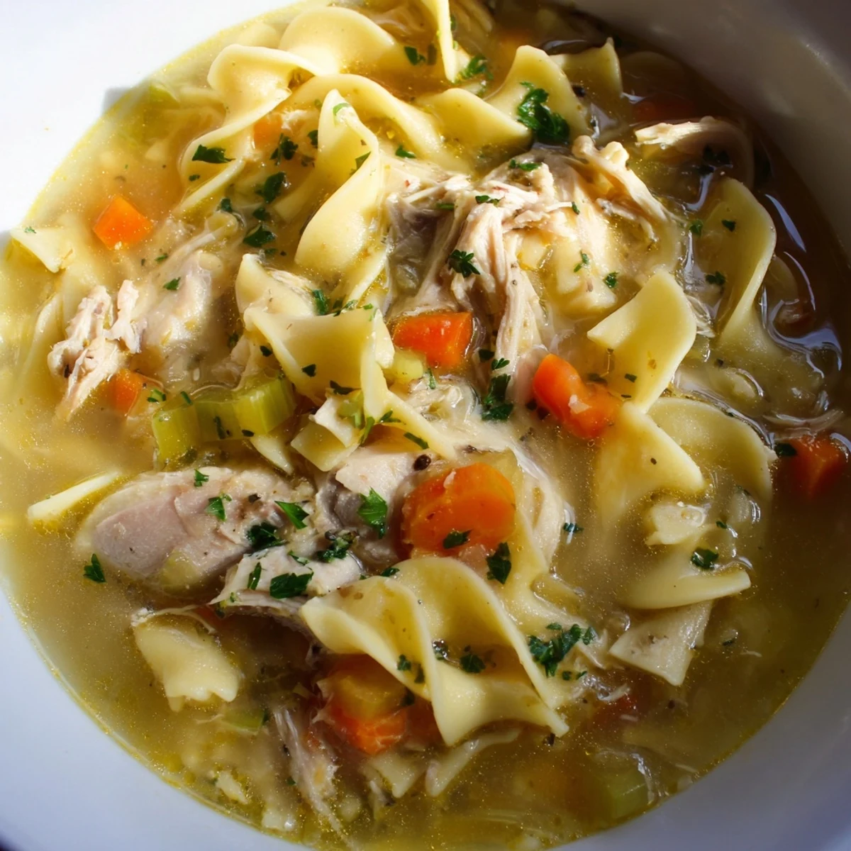 Steaming bowl of Cozy Chicken Noodle Soup, showcasing tender chicken pieces and vibrant vegetables.