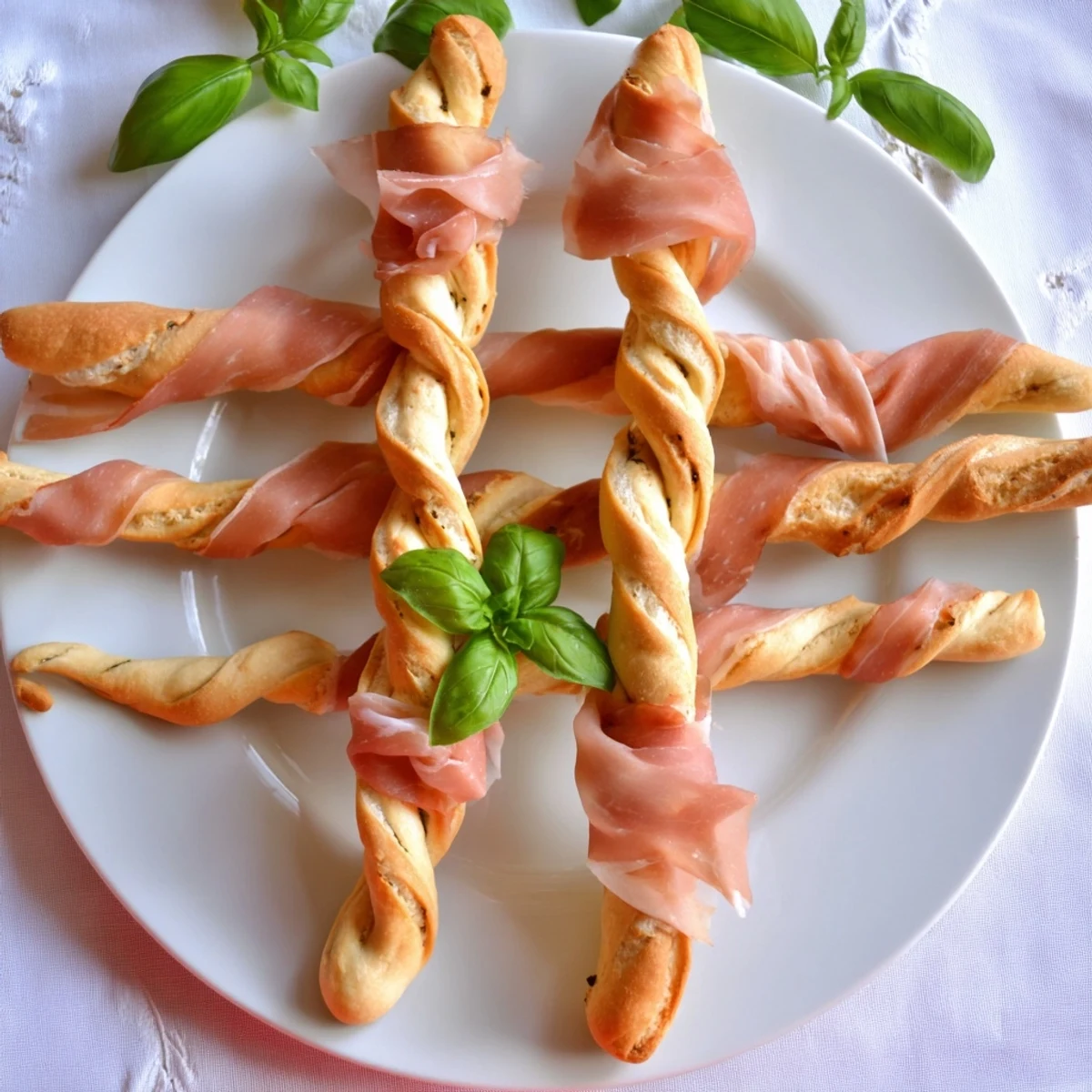 Appetizing Golden Gate appetizer showcasing prosciutto draped artistically over breadstick "towers", ready to enjoy.