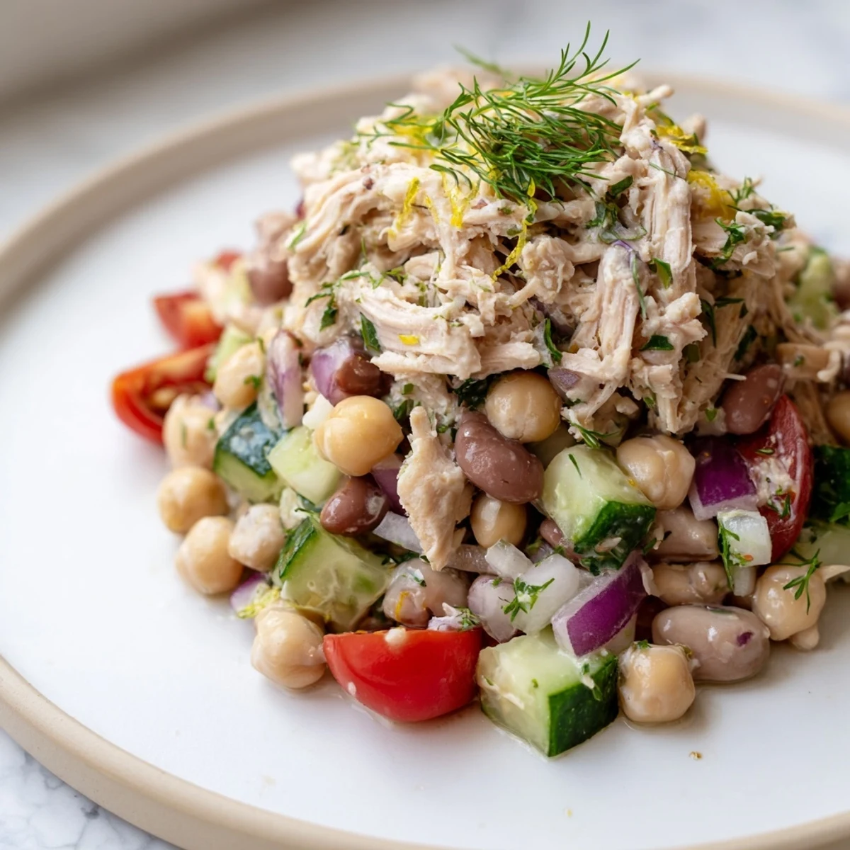 Close-up of the flavorful dense bean salad with lemon-dill chicken, perfect for a light, filling meal.