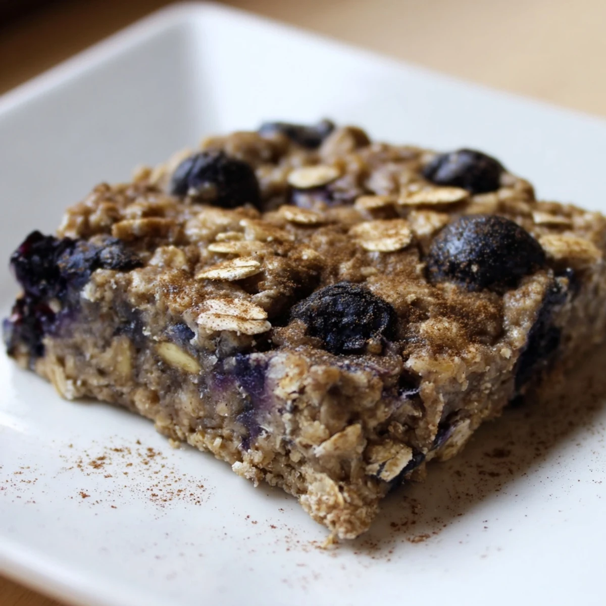 A close-up of baked blueberry banana oatmeal protein bars, showcasing juicy blueberries and golden edges.
