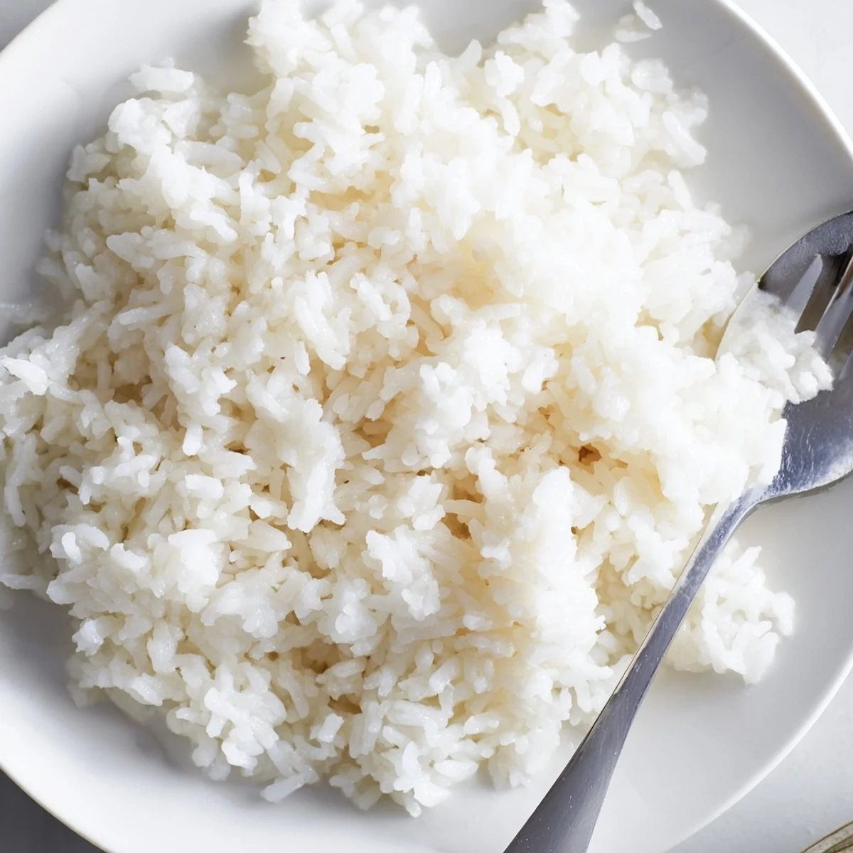 Close-up of golden-hued Coconut Jasmine Rice, perfect for scooping up and enjoying with dinner.