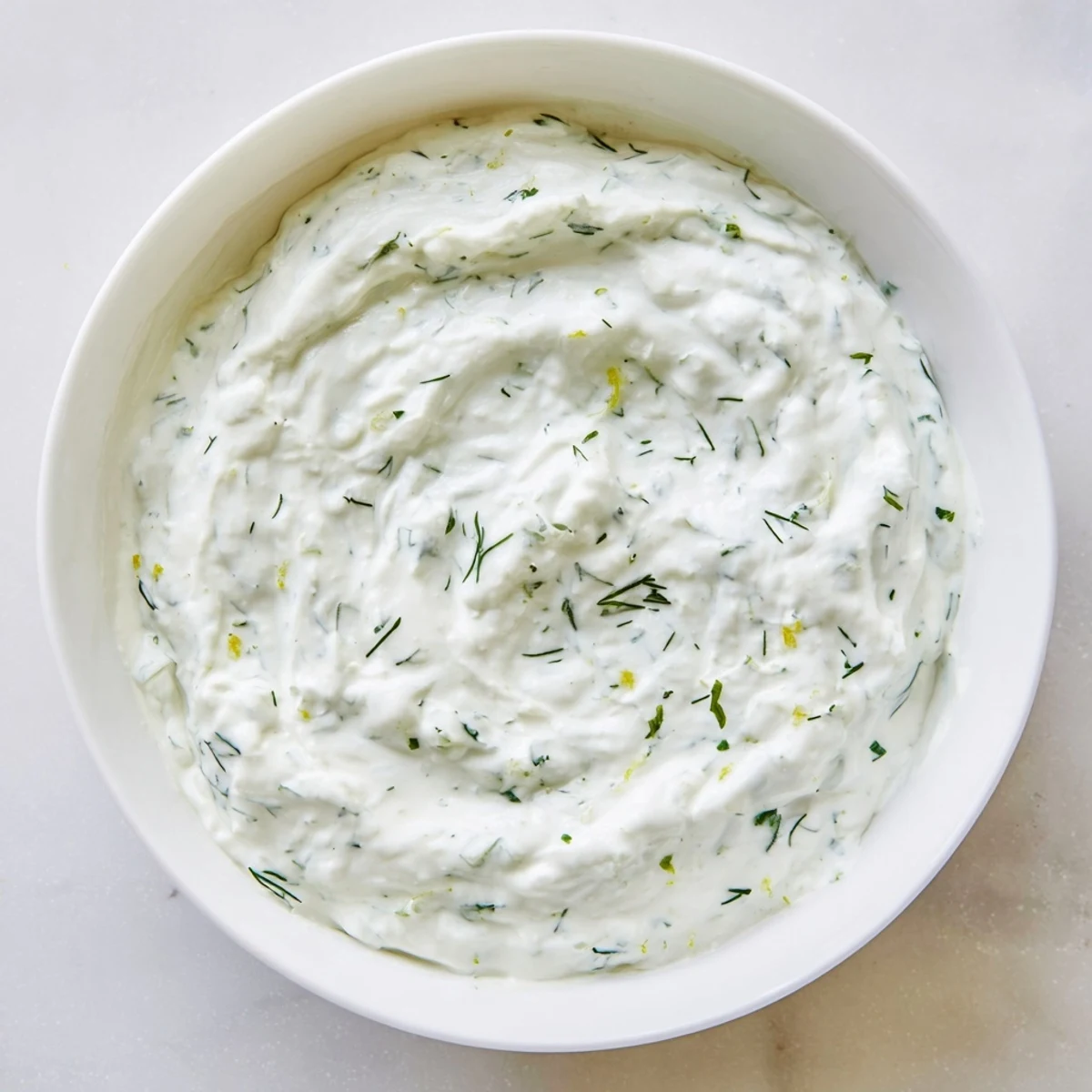Creamy Greek Yogurt Herb Dip with fresh dill, chives, and parsley, served with colorful vegetables and pita chips.  