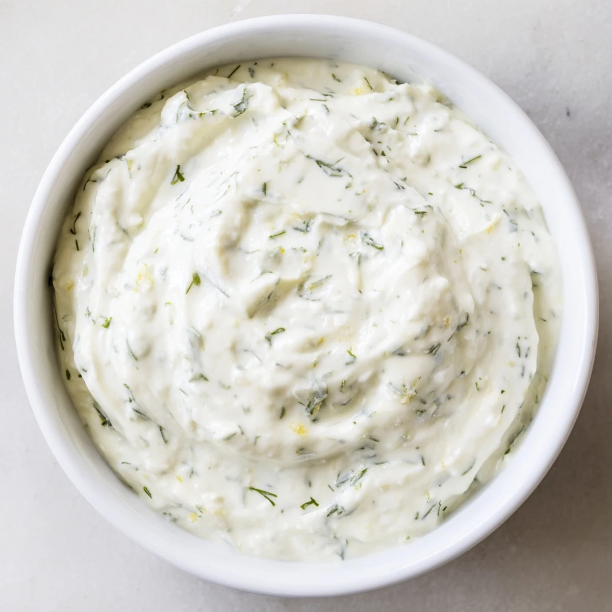Chilled Greek Yogurt Herb Dip in a rustic serving bowl, surrounded by crunchy pita chips and fresh cucumber slices.