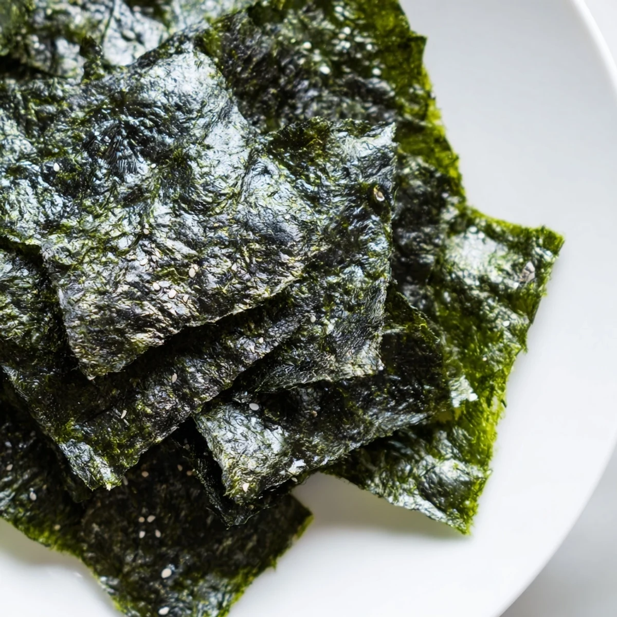 Two stacked nori sheets cut into squares, roasted to a crisp and ready to serve with rice bowls.