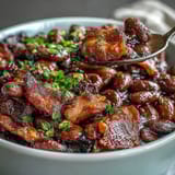 2. Tender navy beans baked in a sweet molasses and ketchup sauce, studded with savory bacon and diced vegetables for a classic barbecue side.