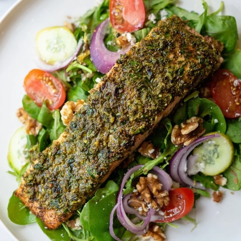 Fragrant herb-crusted salmon salad, ready to eat, featuring flaky salmon atop fresh greens.