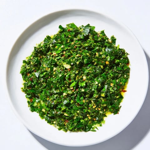 Bright green Moroccan Chermoula Marinade ready to coat fresh fish for an aromatic flavor infusion.
