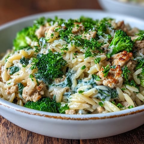 Creamy Garlic Turkey & Broccoli Orzo simmering in a skillet with golden parmesan and tender green broccoli florets.