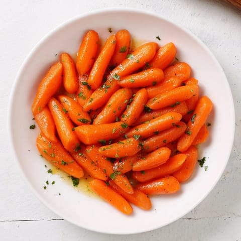 Golden honey-glazed carrots, glistening and tender, ready to serve as a delicious, simple side dish.