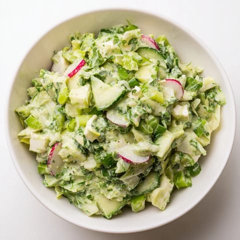 Freshly tossed Green Goddess Cabbage Dip, a vibrant appetizer ready to scoop up with crunchy tortilla chips.