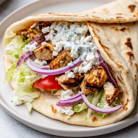 Warm pita bread holds flavorful Greek Chicken Souvlaki Wraps, a delicious and easy lunch or dinner.