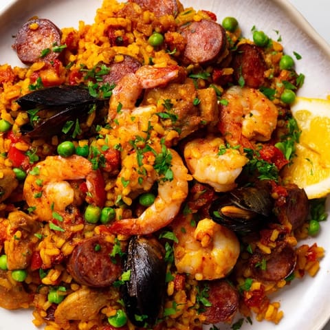 Steaming Paella Spanish Rice with saffron-infused rice and a medley of seafood, perfect for sharing.