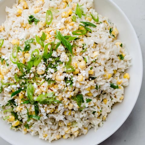 A bowlful of flavorful Mexican Street Corn Rice, with zesty lime and a sprinkle of chili powder.