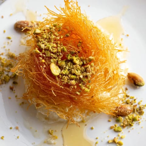 Irresistibly delicious, this warm Lebanese Knafeh features rich cheese, crispy phyllo, and sweet syrup.