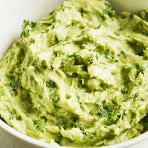 Creamy Avocado Lime Dip served with colorful vegetable crudités and crunchy tortilla chips on the side.  