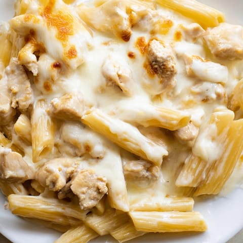 A comforting family dinner of creamy Chicken Alfredo Casserole with tender pasta and hearty chicken pieces.  