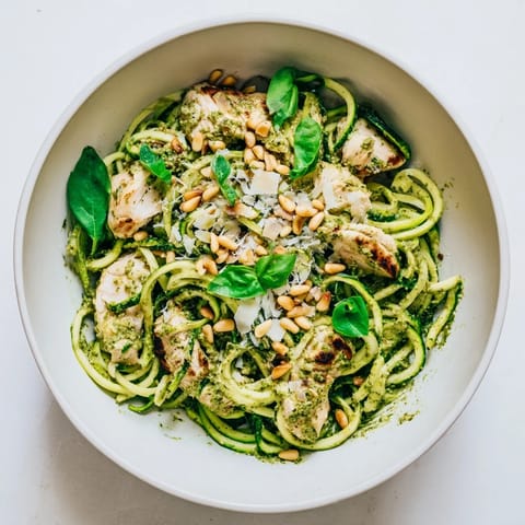 Spiralized zucchini noodles tossed with tender chicken and aromatic basil pesto create a light, summery main dish.  