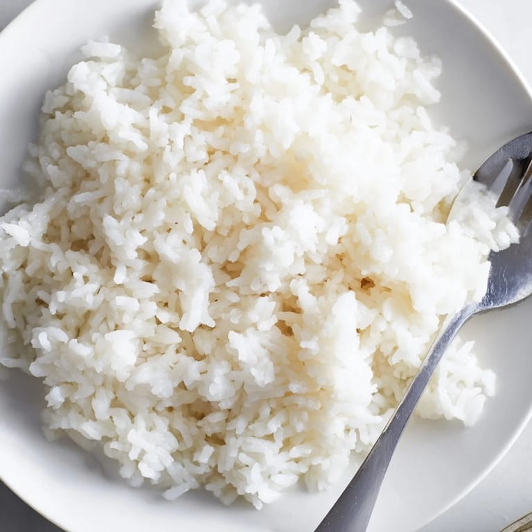 Close-up of golden-hued Coconut Jasmine Rice, perfect for scooping up and enjoying with dinner.