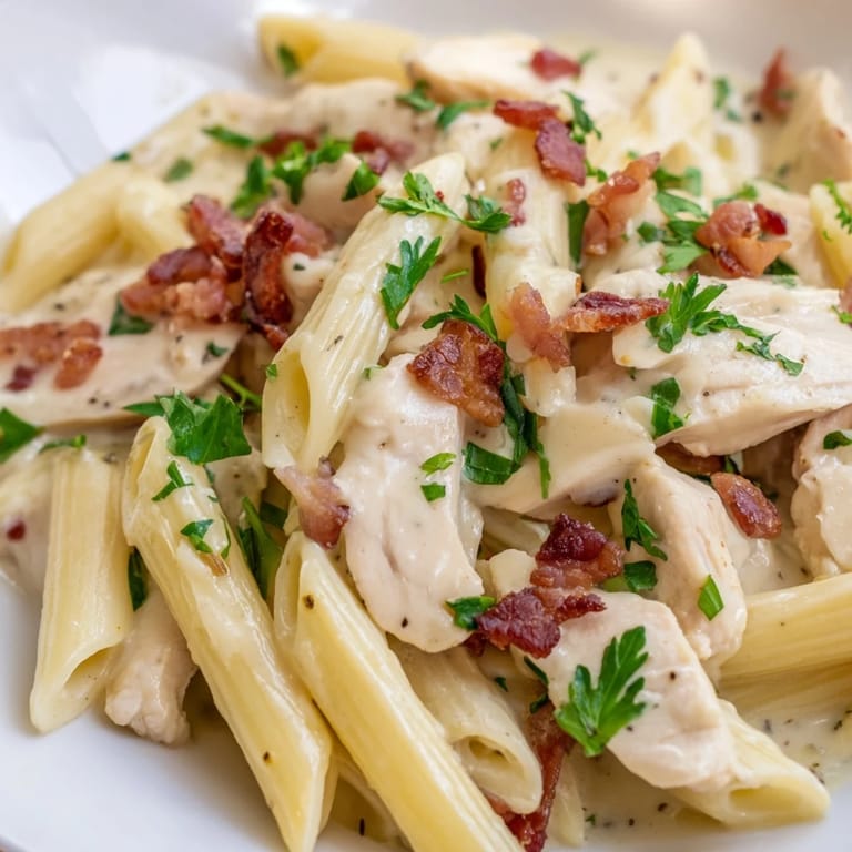 Overhead view of Creamy Chicken Bacon Penne, showing penne noodles coated in luscious sauce with chicken and bacon.