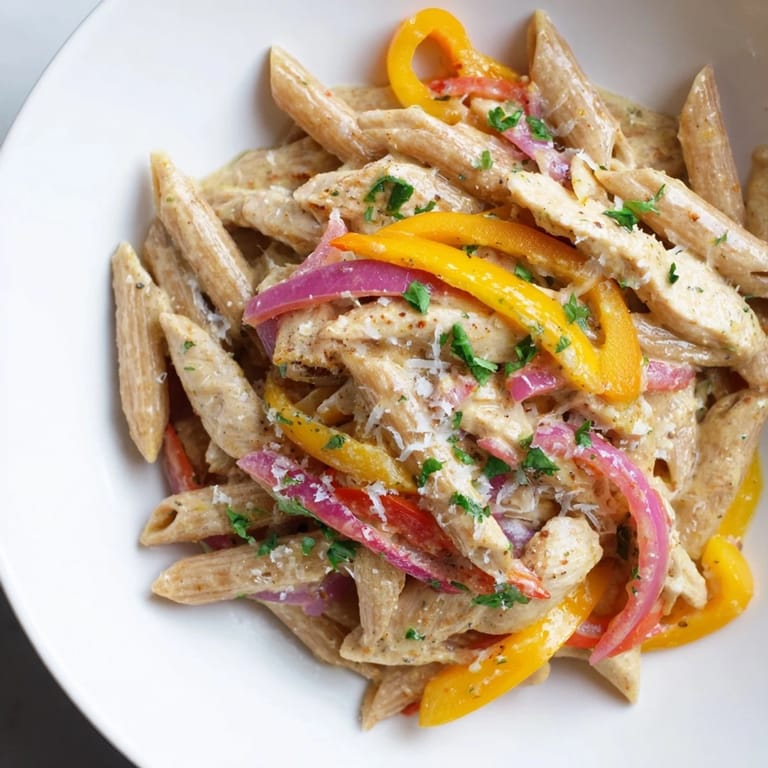 A fork twirls creamy penne from this Creamy Cajun Chicken Pasta Lite, perfect for a healthy weeknight dinner.