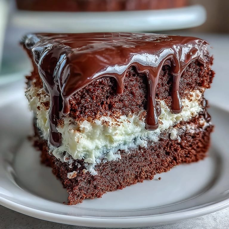 Elegant white chocolate drip graduation cake topped with shimmering gold balloon decorations.  